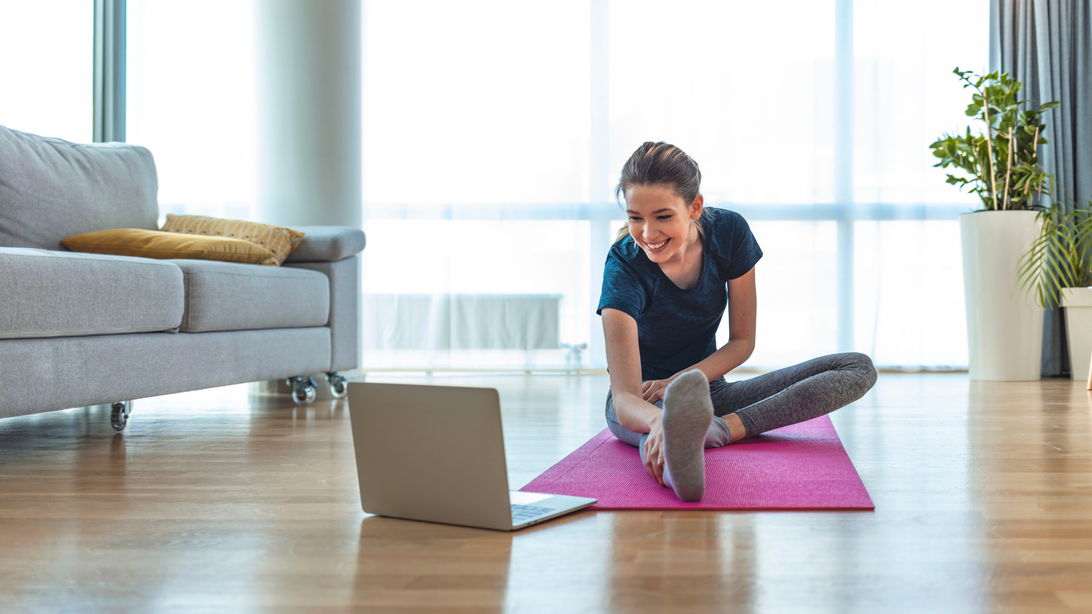 Woman smiling while working out at home on yoga mat